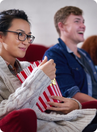 Chica viendo una película en el cine sosteniendo unas palomitas